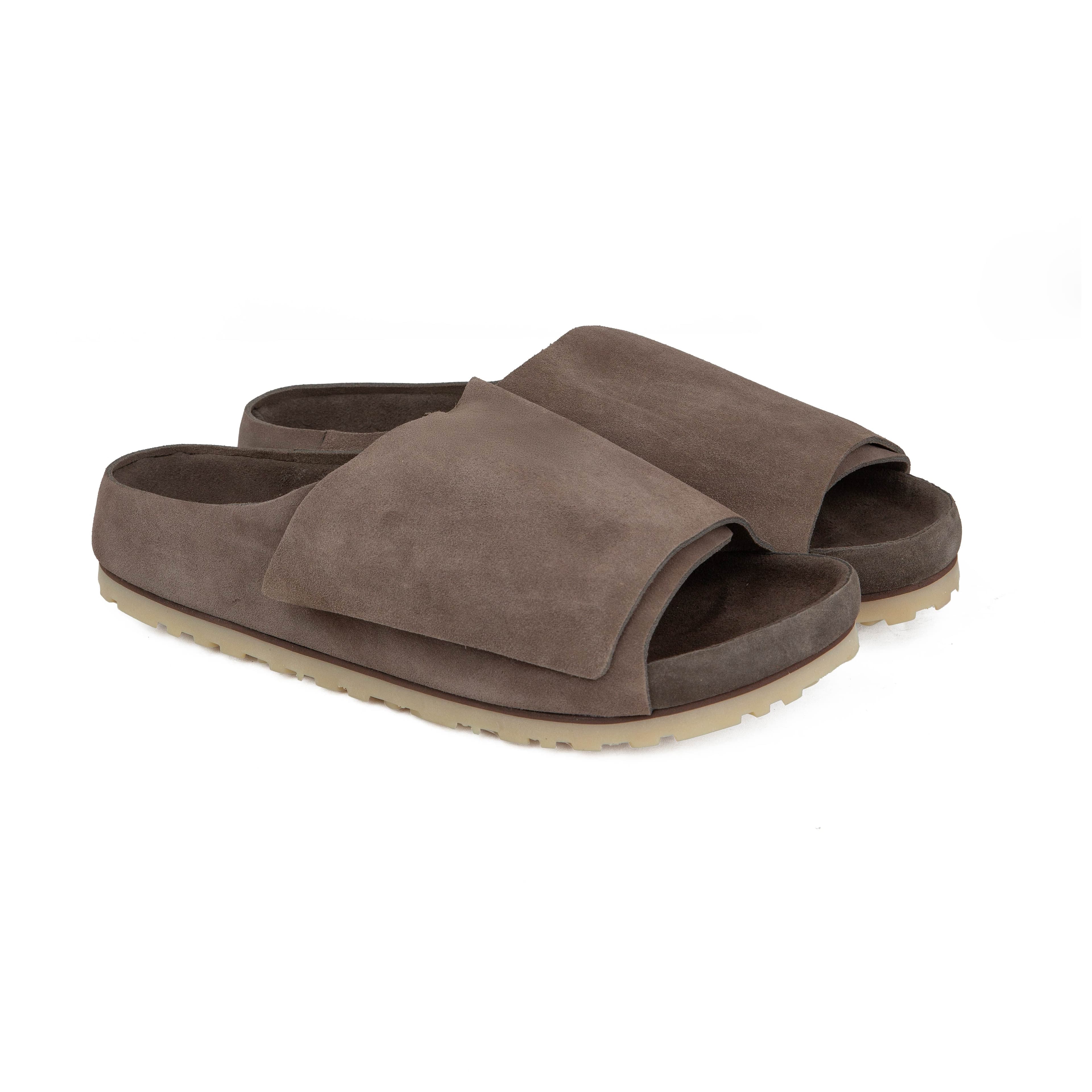 Side view of Fear of God x Birkenstock Los Feliz taupe suede slides with adjustable strap and cork footbed.