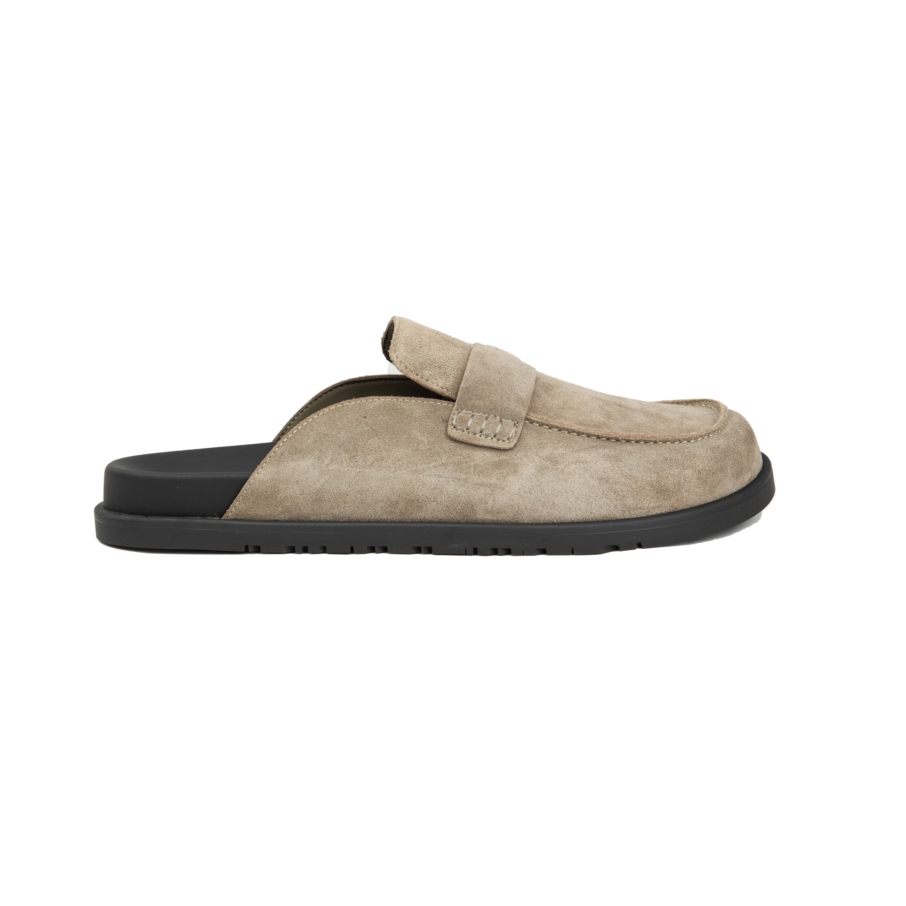 Pair of warm taupe Etoupe suede Hermès Ancora mules with tonal H strap and black rubber soles on a white background