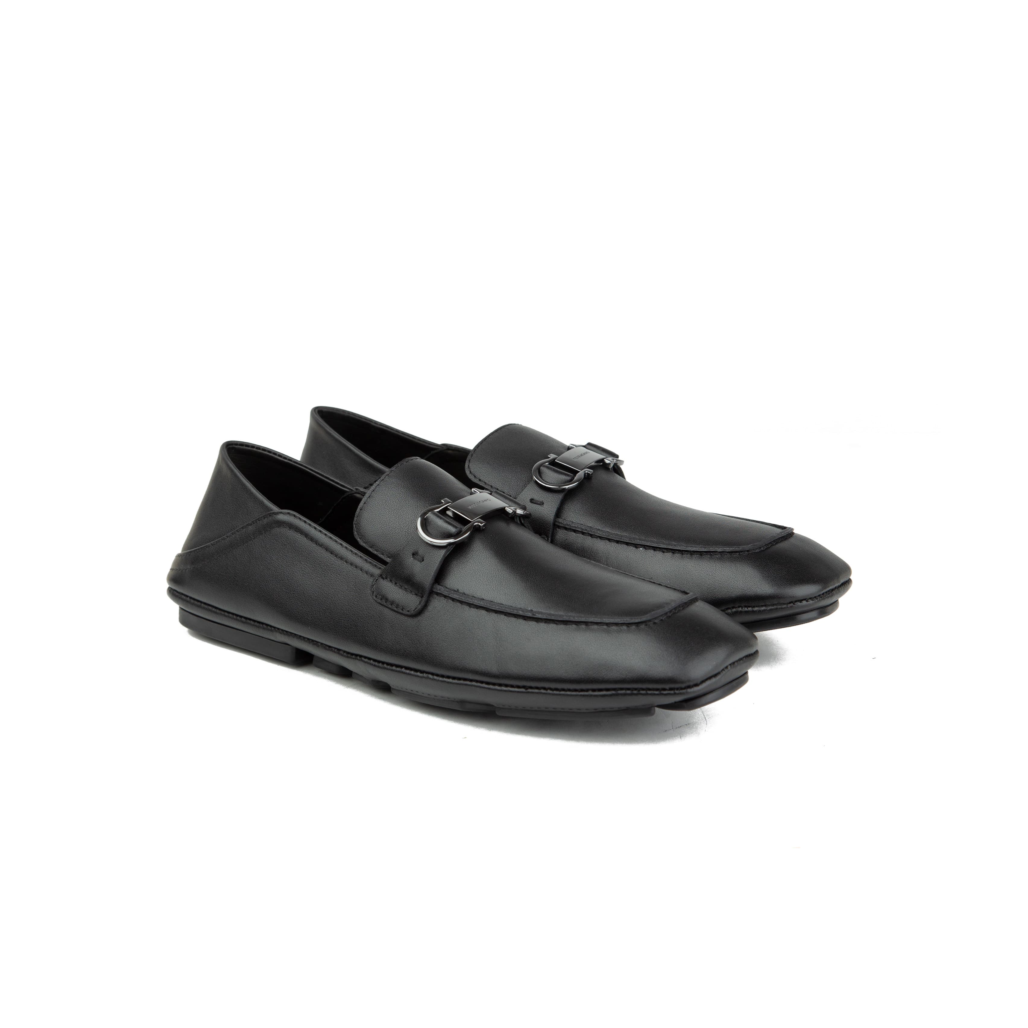 Pair of black Ferragamo Gancini leather driver loafers with silver buckle on a white background.