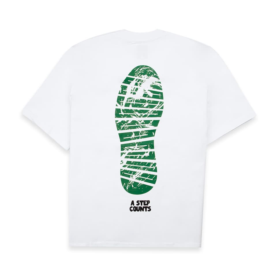 White t-shirt with green footprint graphic and "A Step Counts" text. Unique graphic tee.