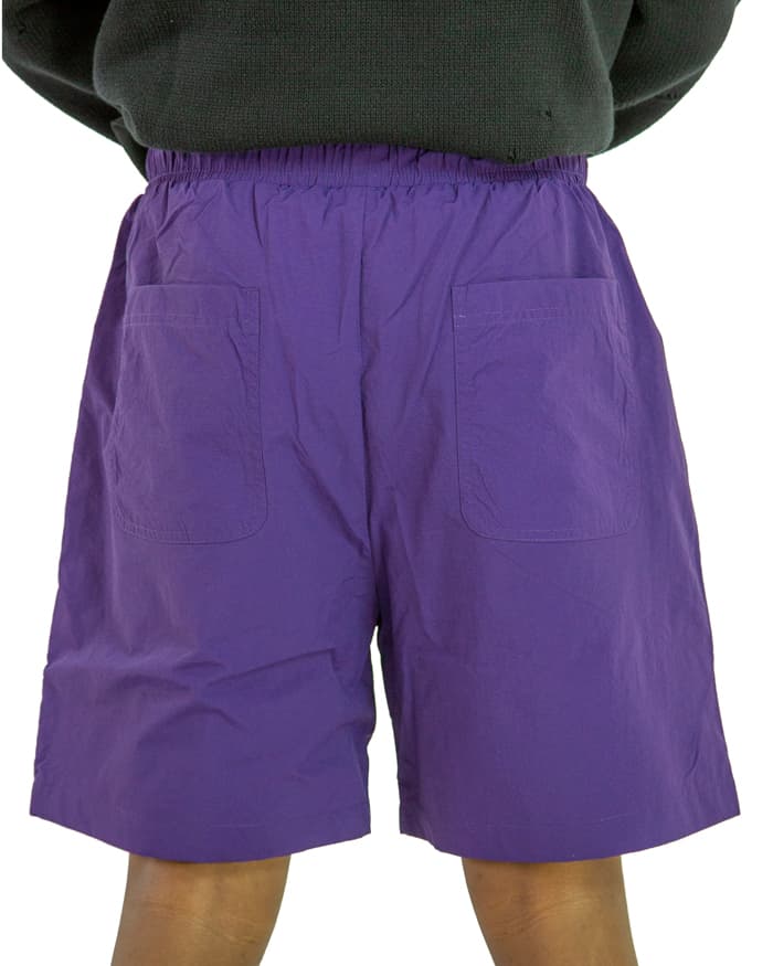 Purple nylon swim shorts with elastic waistband and drawstring closure.