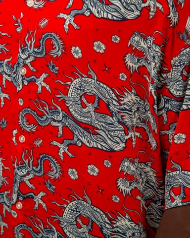 Men's white short sleeve button-down shirt with artistic tropical print featuring peacocks, abstract designs, and botanical elements.