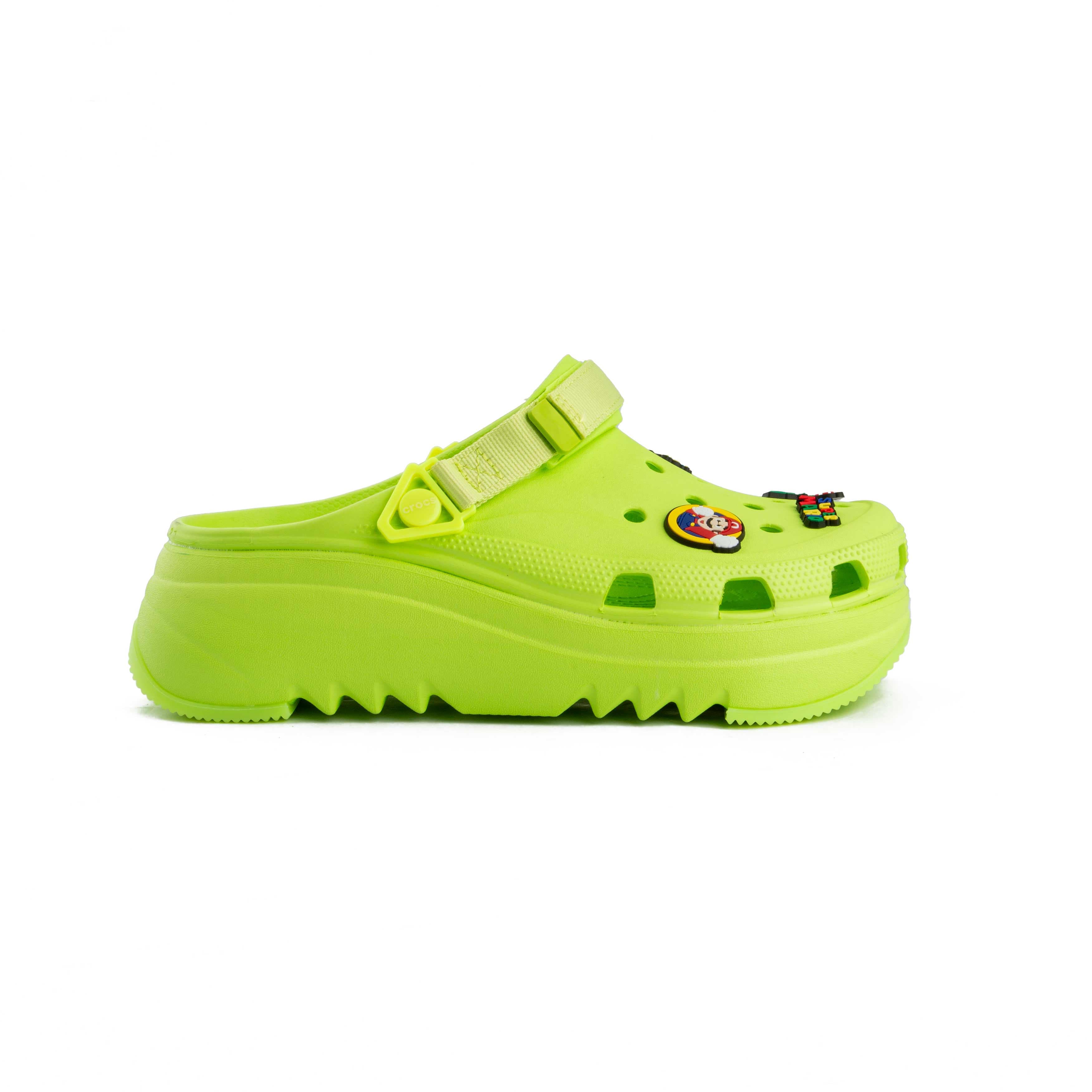 Lime green platform clogs with assorted colorful decorative charms, side view.