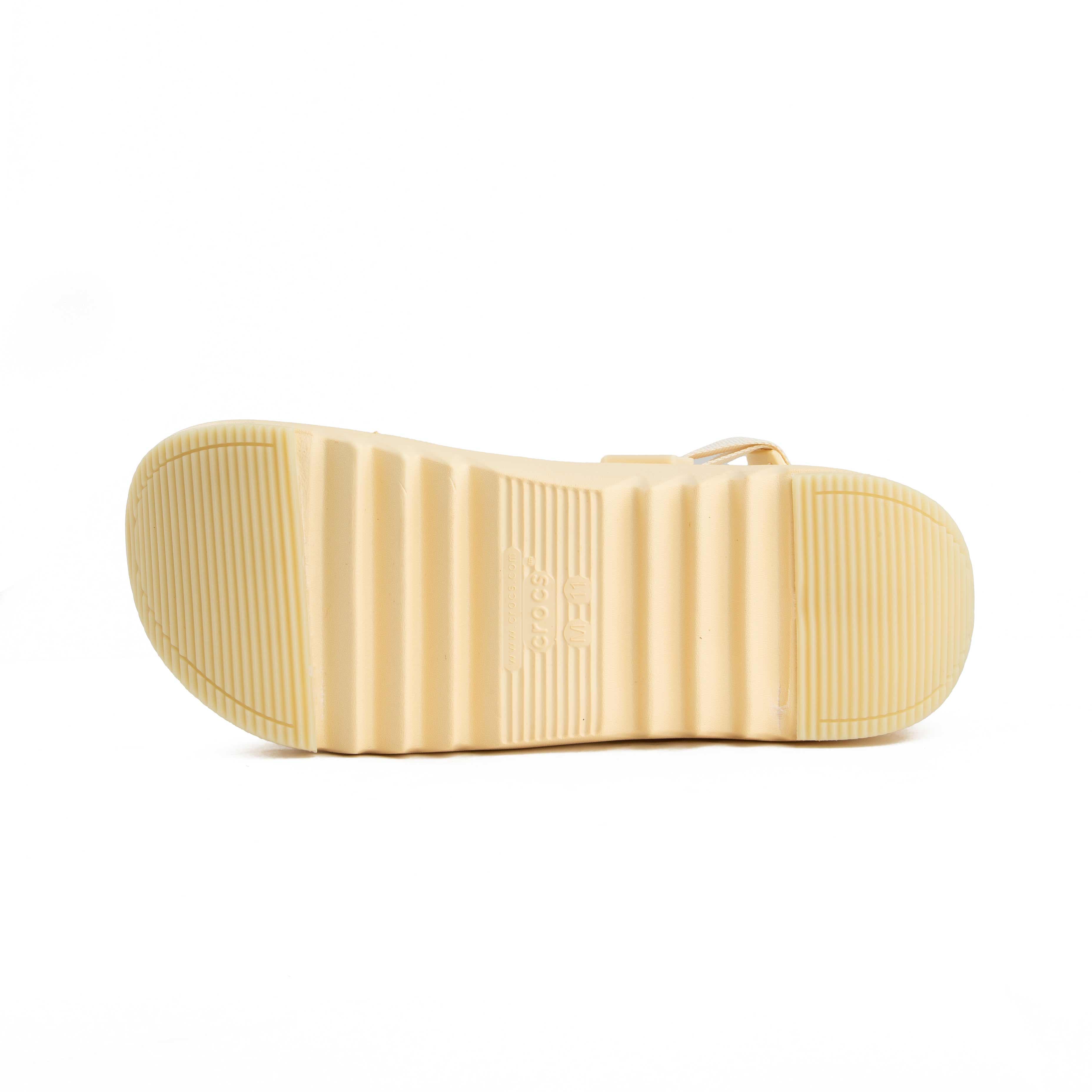 Cream platform clogs with assorted nature-themed decorative charms, side view.