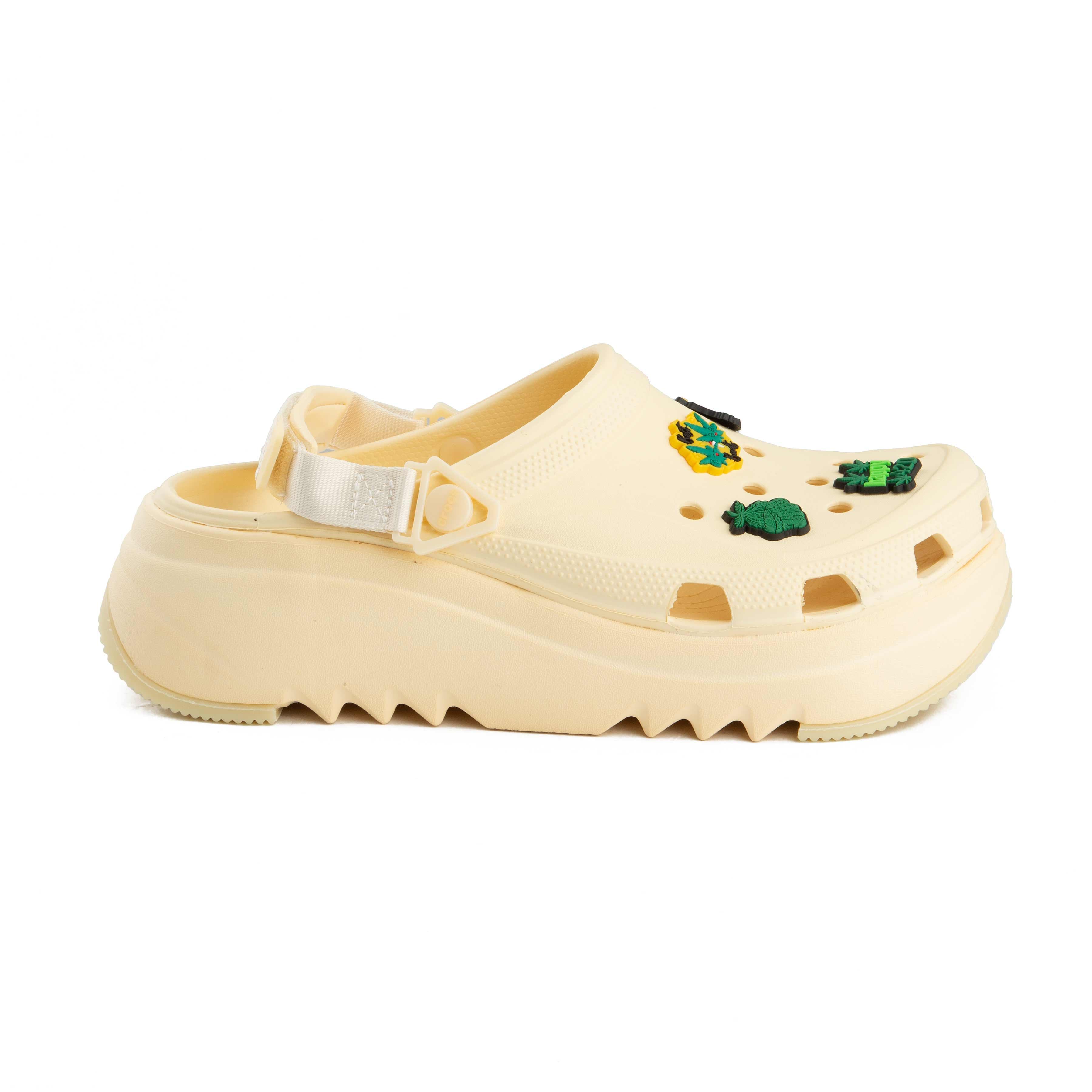 Cream platform clogs with assorted nature-themed decorative charms, side view.