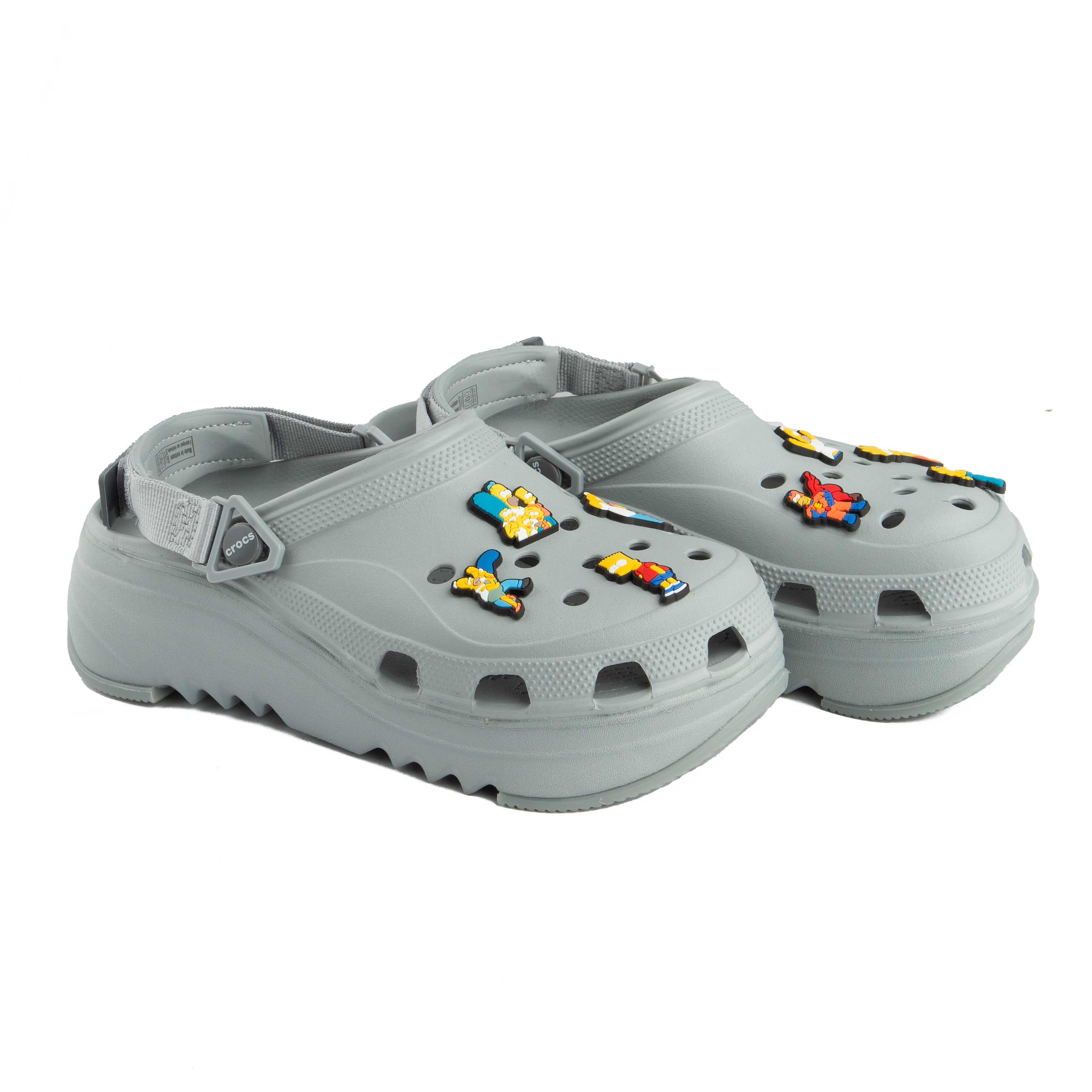 Grey platform clogs with assorted colorful character decorative charms, side view.