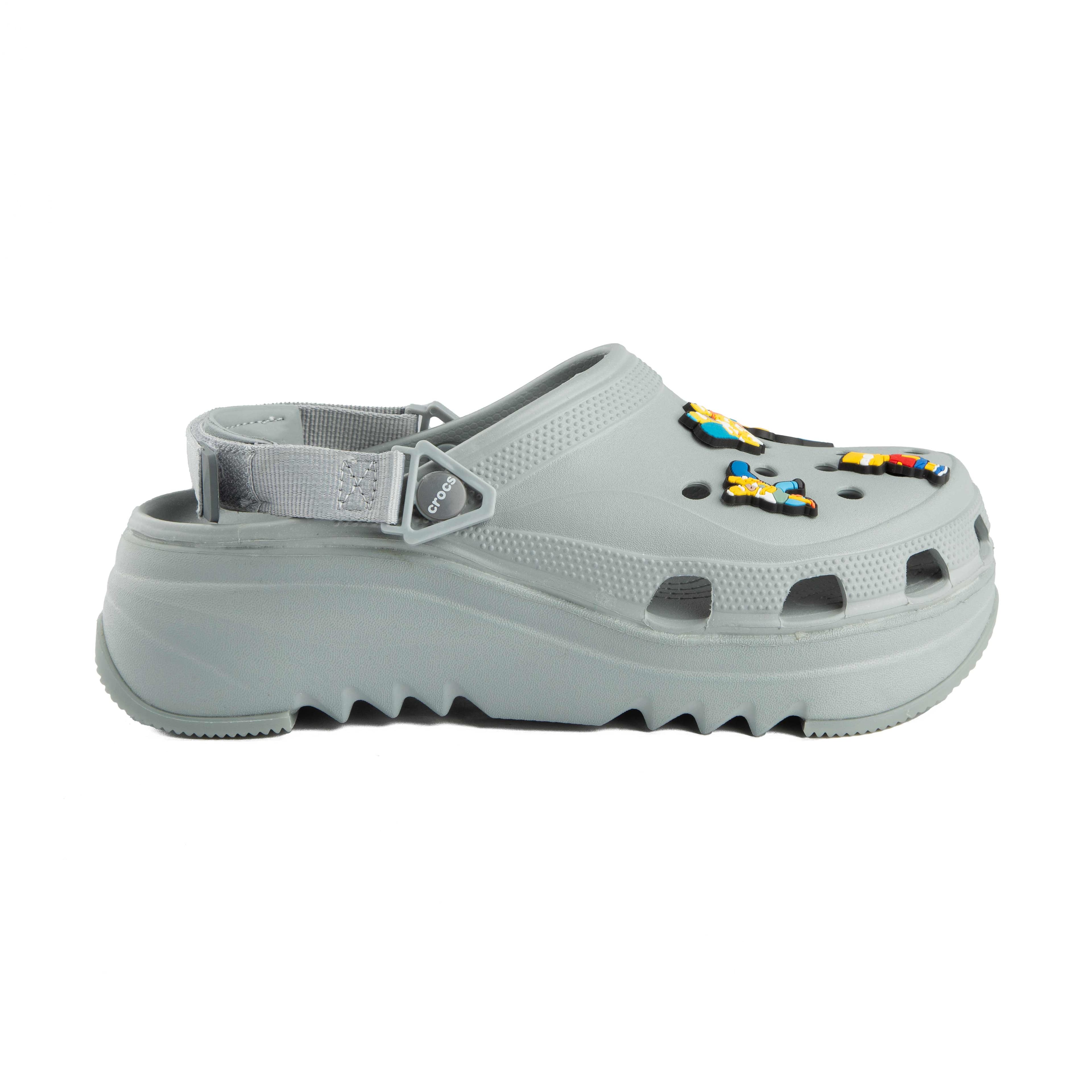 Grey platform clogs with assorted colorful character decorative charms, side view.