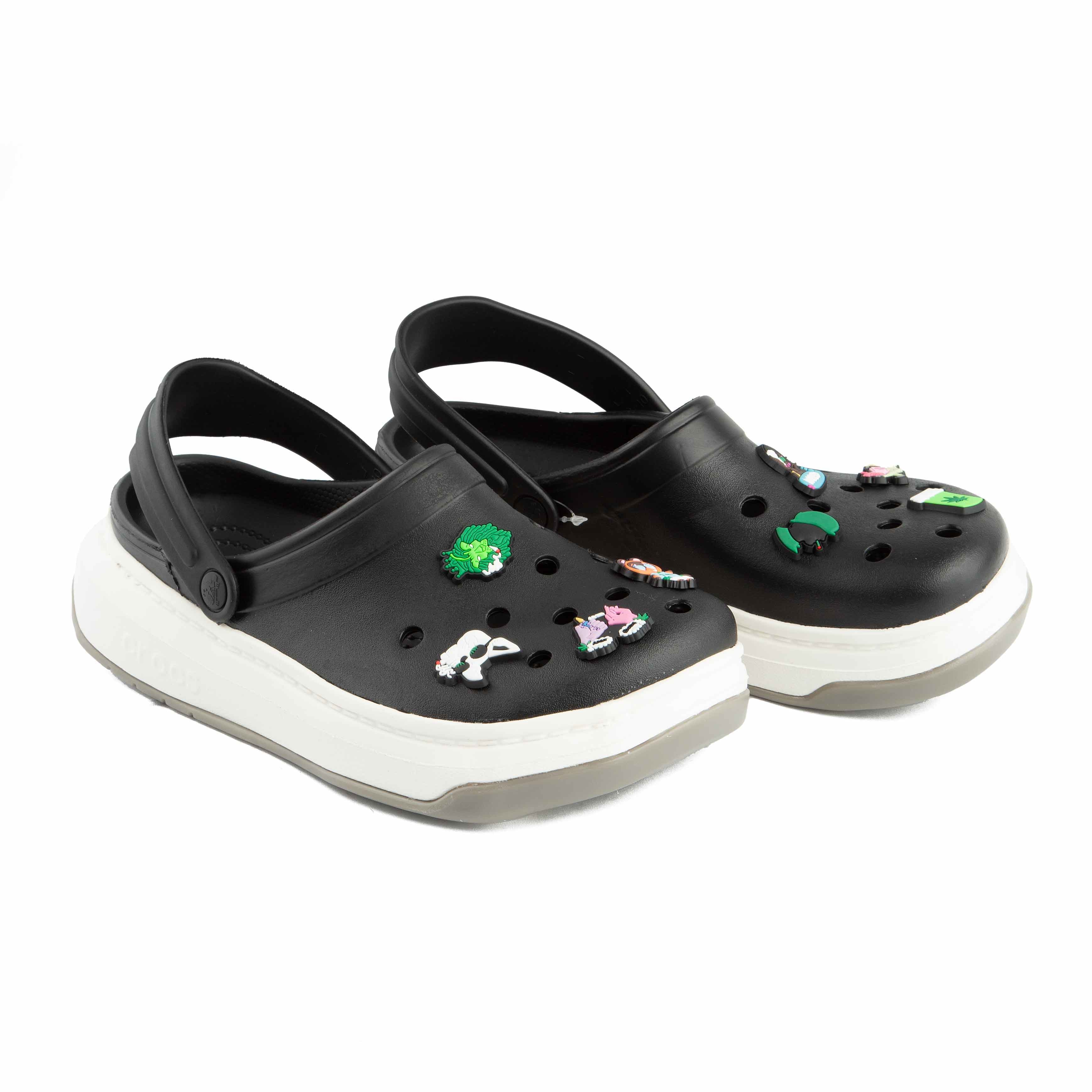 Two-tone black and white platform clogs, side view.