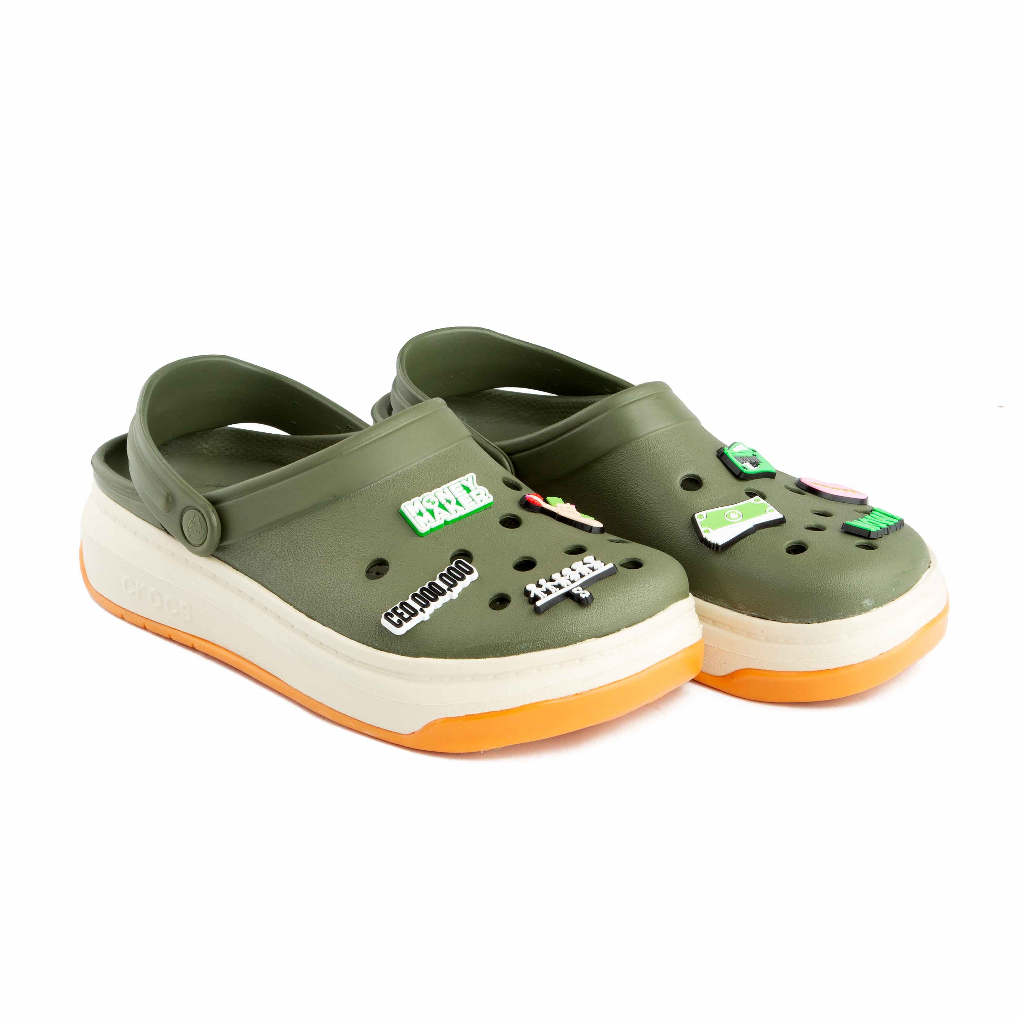 Olive green platform clogs with assorted urban and money-themed decorative charms, side view.
