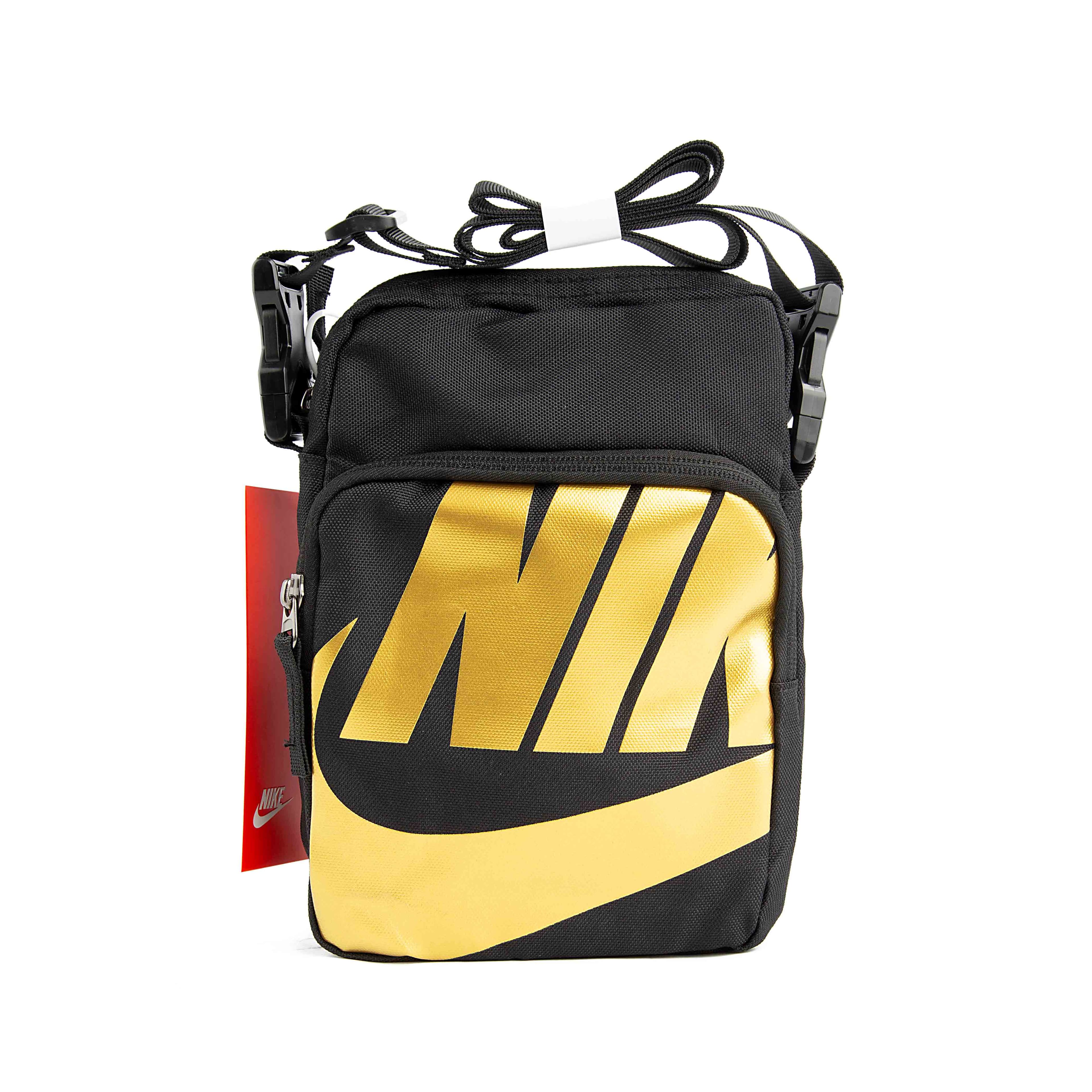This is a compact, rectangular shoulder bag. The bag is made of a durable, textured black fabric and features an adjustable shoulder strap. 