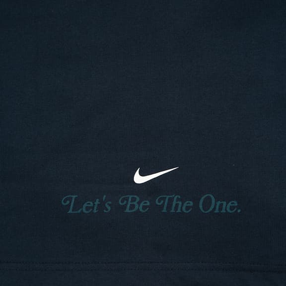 A Nike Men's vintage-style rugby polo shirt in navy with a teal stripe across the chest and a stylized embroidered Nike logo.