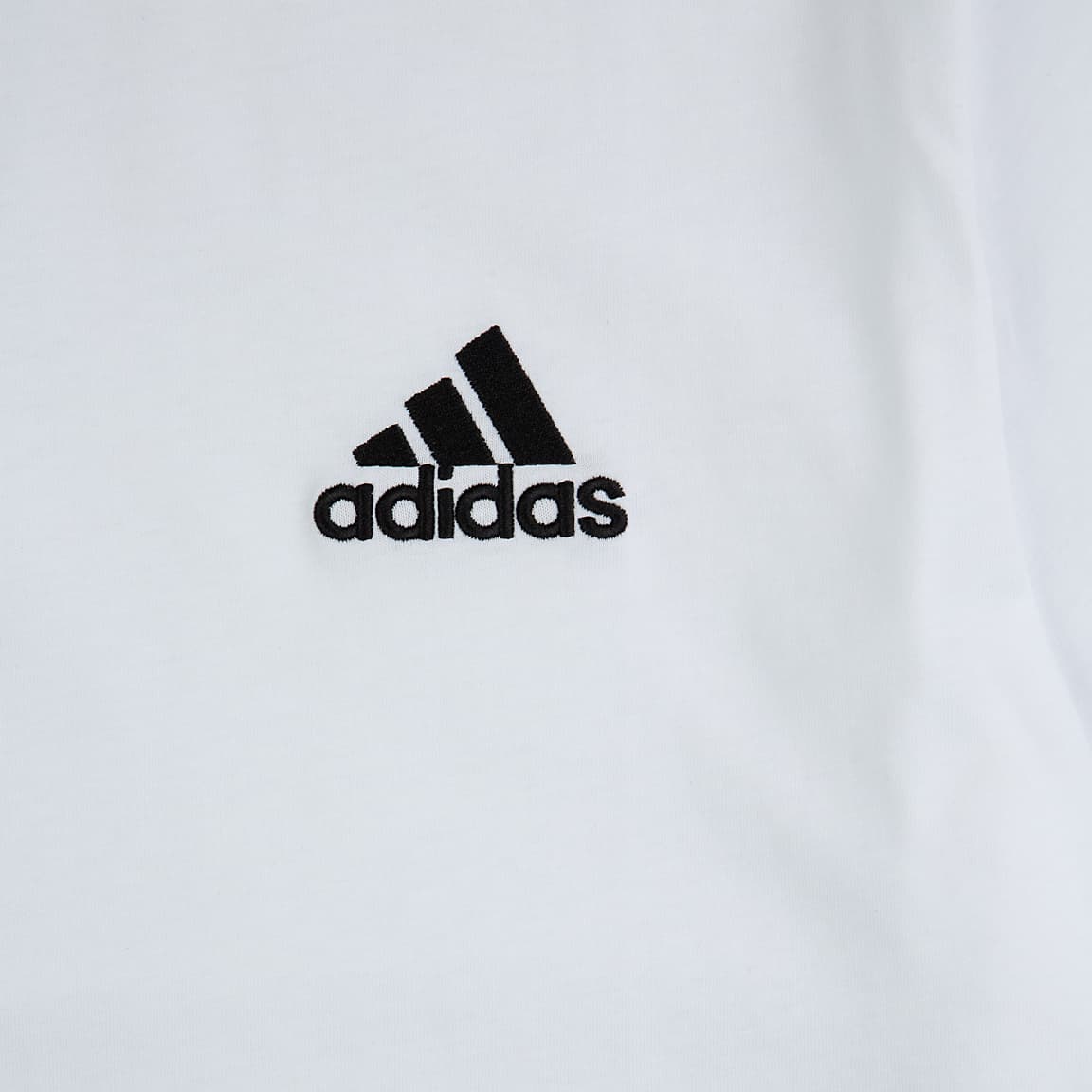 A white Adidas  T-Shirt with a small, black Adidas logo on the left chest.