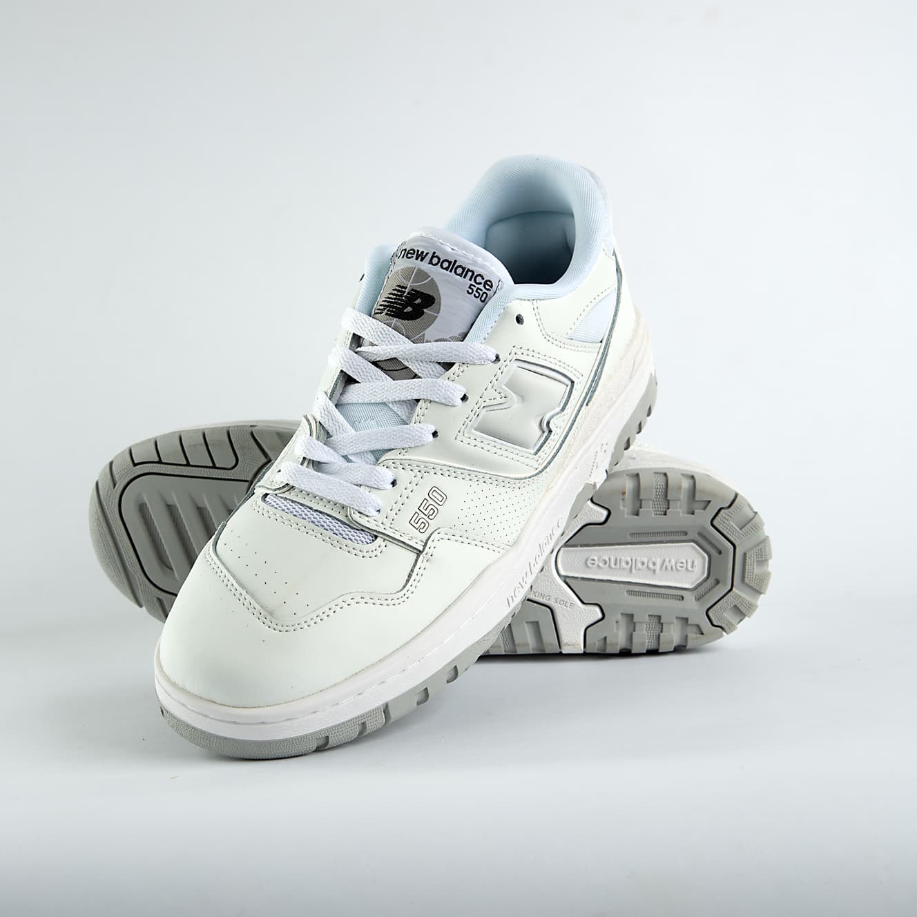    New Balance 550 sneakers in an off-white and light gray colorway. A classic low-top style with a minimalist look for men and women.