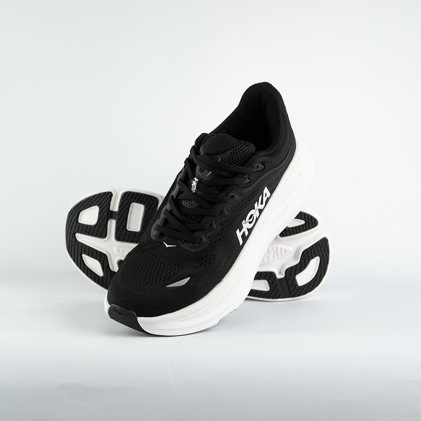 A pair of black and white Hoka Bondi 9 Sneakers cushioned road running shoes, known for maximum comfort and support for everyday runs and walks.