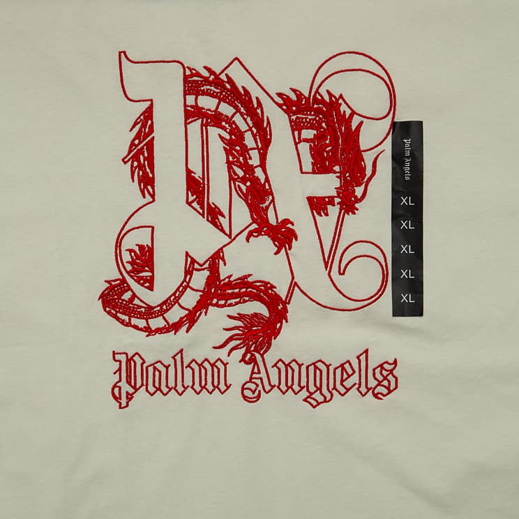 This is a cream/off-white, short-sleeved, crew-neck t-shirt from the streetwear luxury brand Palm Angels.