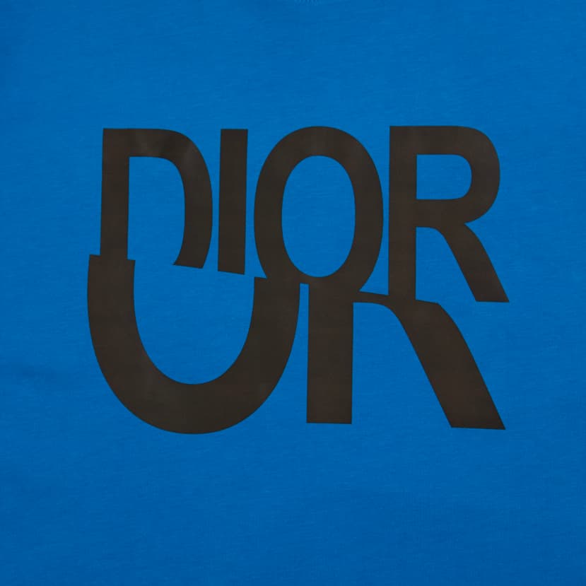 Royal blue Christian Dior t-shirt with large black inverted and overlapping logo graphic, luxury unisex wear.