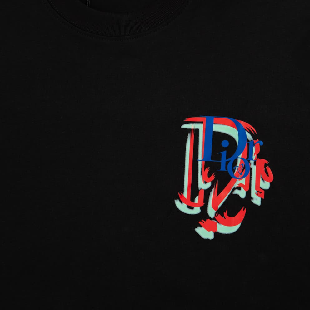 Black Christian Dior t-shirt with small, multi-colour distorted 'D' logo graphic on chest, luxury unisex wear.
