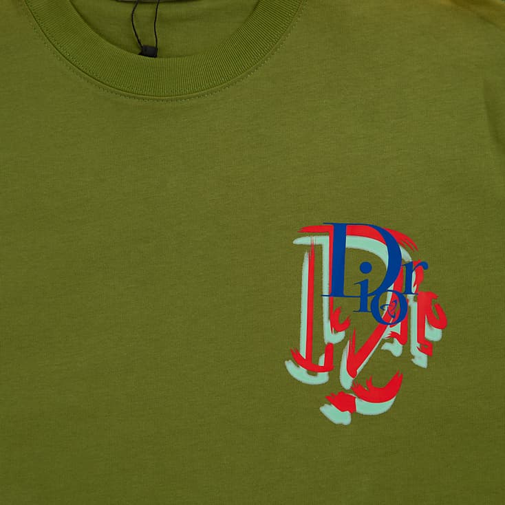 Olive Green Christian Dior t-shirt with small, multi-colour distorted 'D' logo graphic on chest, luxury unisex wear.