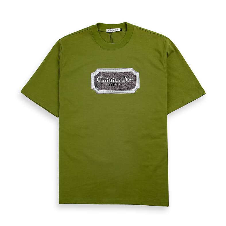 Olive Green Christian Dior t-shirt with brown couture patch logo graphic on chest, luxury unisex style.