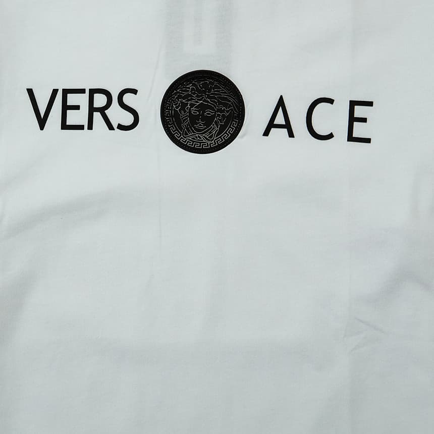 A classic short-sleeved, crewneck T-shirt featuring the iconic Versace Medusa motif placed centrally between the "VERS" and "ACE" lettering.