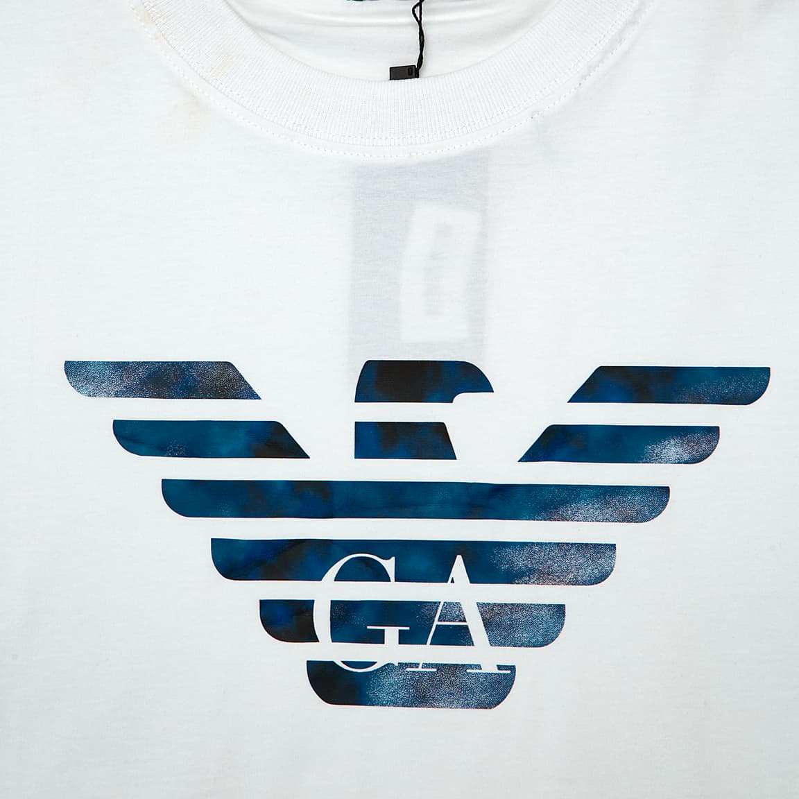 White Emporio Armani t-shirt with large blue and black marbled Eagle logo on chest, designer unisex casual wear.