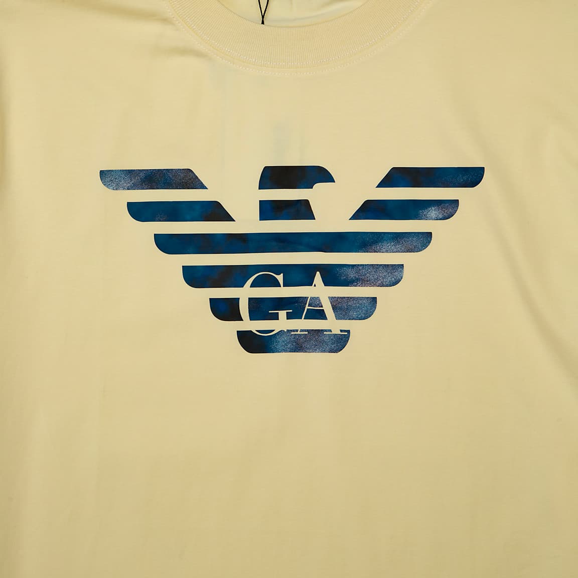 Pale Yellow Emporio Armani t-shirt with large blue and white marbled Eagle logo on chest, designer unisex casual wear.