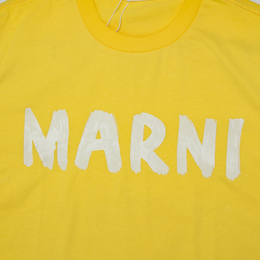 Yellow Marni t-shirt with large white brushstroke logo graphic on chest, short sleeves, designer unisex streetwear.