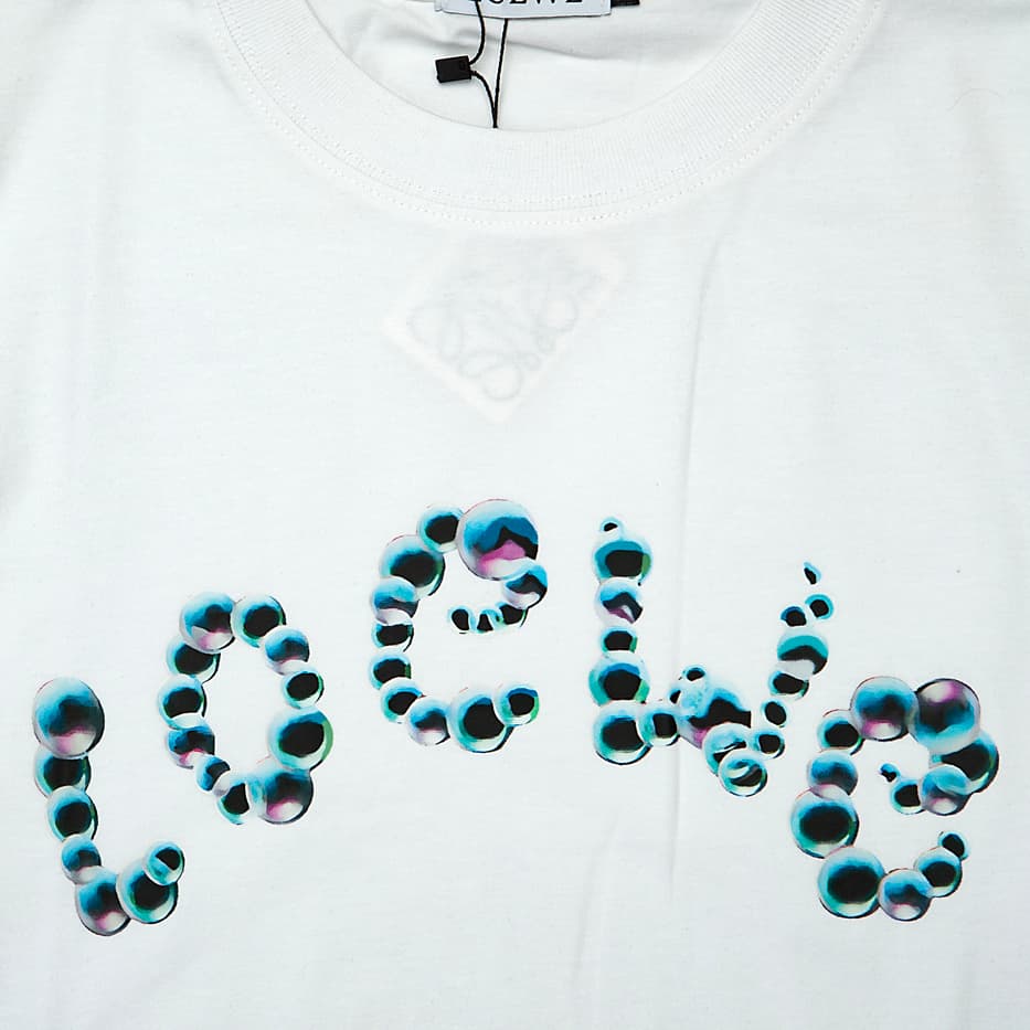 White Loewe t-shirt with large blue/teal animal print bubble logo on chest, short sleeves, luxury unisex designer wear.