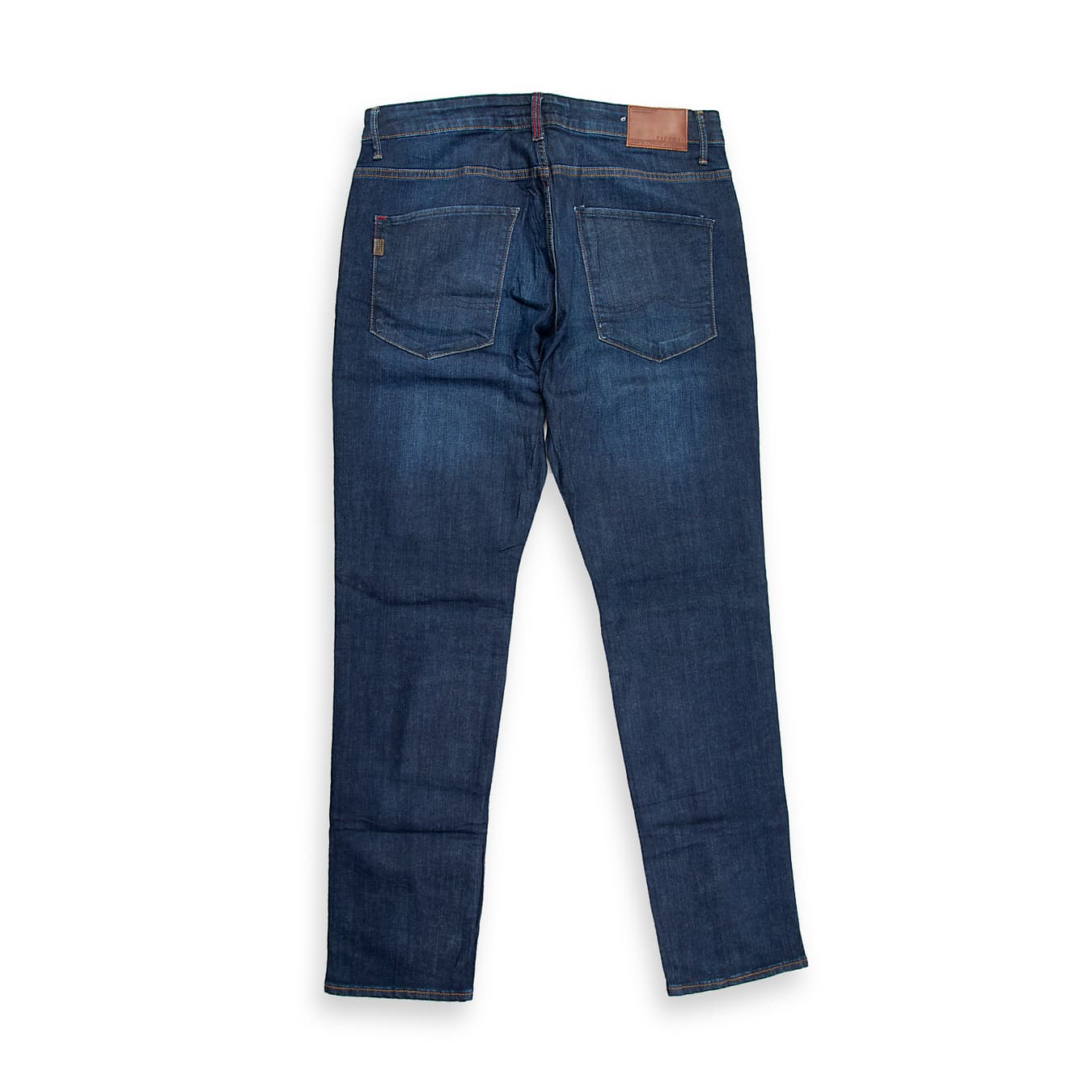 These are a pair of slim-straight fit jeans in a deep, rich dark indigo blue wash. The denim has a clean, saturated appearance with only subtle, natural whiskering and fading on the upper thighs, providing depth without the distraction of heavy distressing.