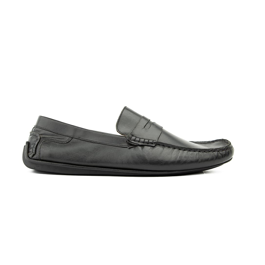 The Midnight Drive Loafer is a sophisticated, classic men's slip-on shoe. It features a traditional penny loafer silhouette with a soft, supple black leather construction, ideal for comfortable, elegant wear.