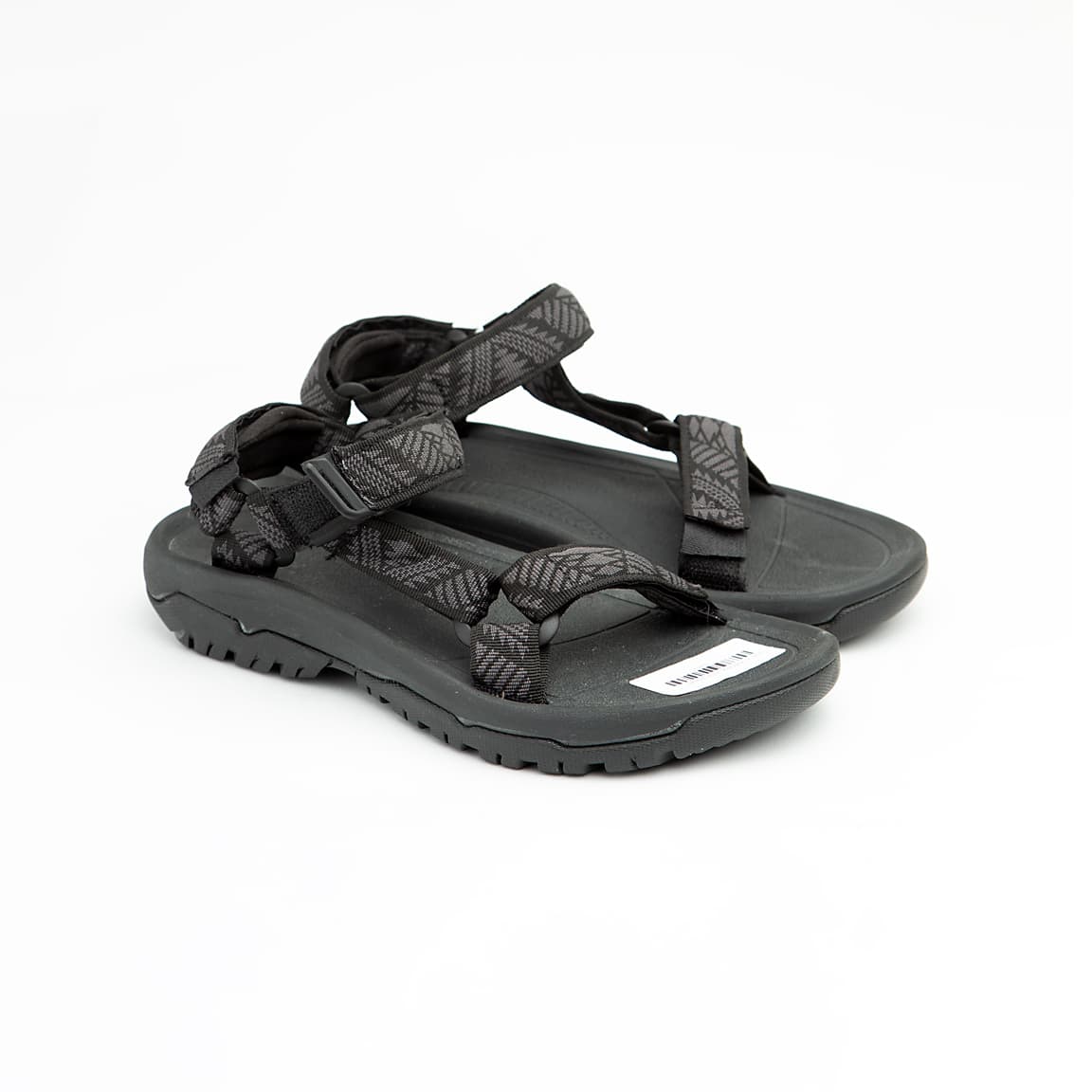 Black all-terrain unisex sport sandals with patterned adjustable straps and rugged rubber sole.