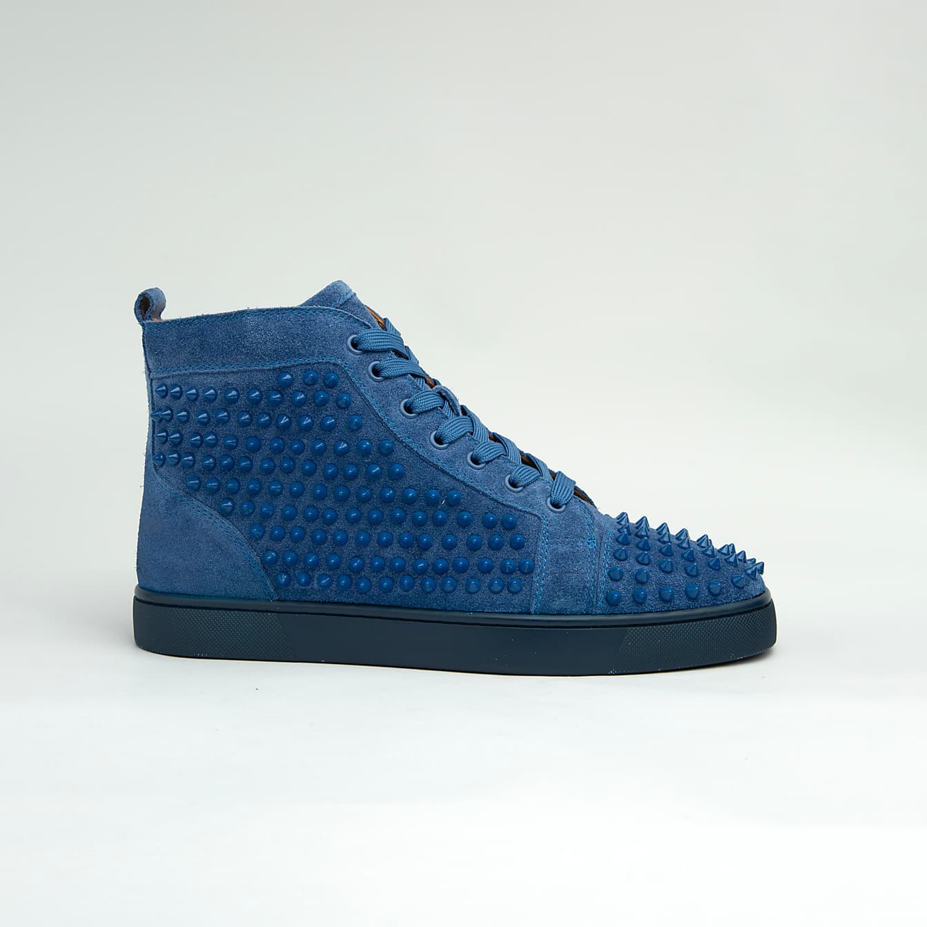 The Cobalt Studded Street is a defiant, high-top luxury sneaker designed for maximum statement impact.