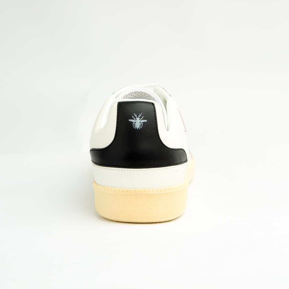 Crafted from smooth white calfskin leather, the shoe is accented by a subtle cream suede toe cap.