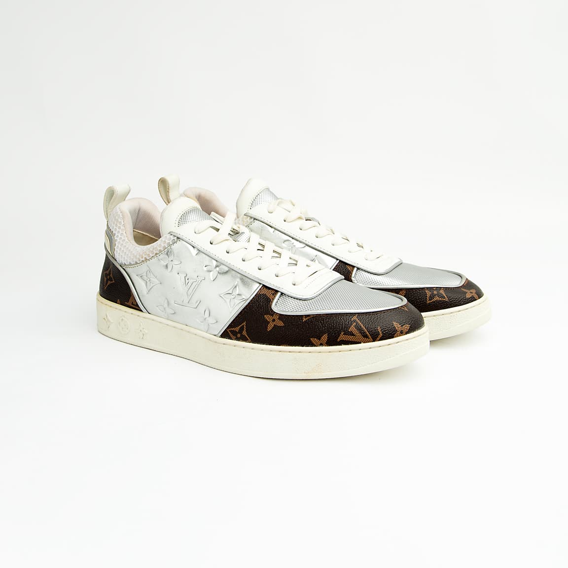 Dual-tone brown and silver unisex monogram embossed leather sneakers with classic design and comfortable sole.