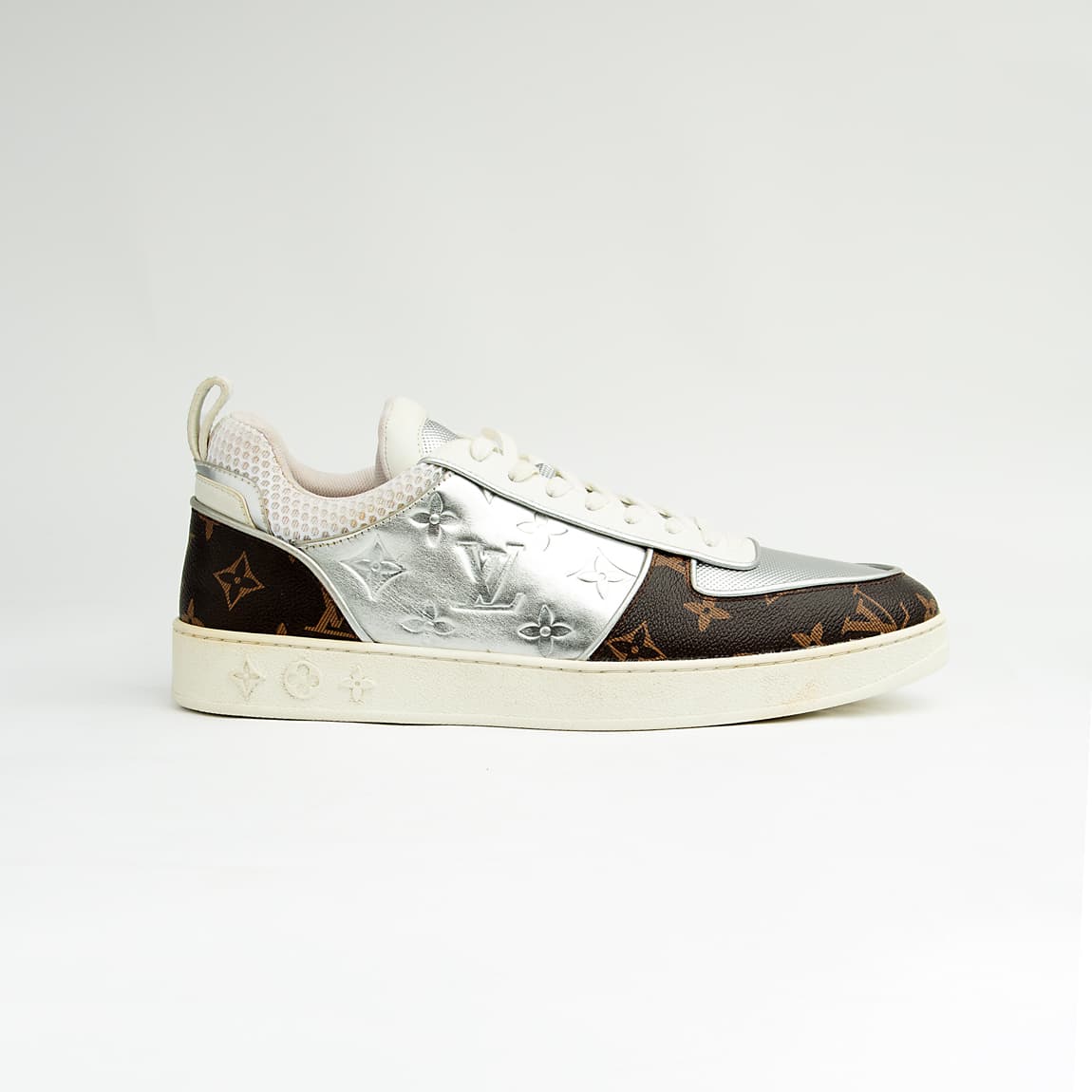 Dual-tone brown and silver unisex monogram embossed leather sneakers with classic design and comfortable sole.