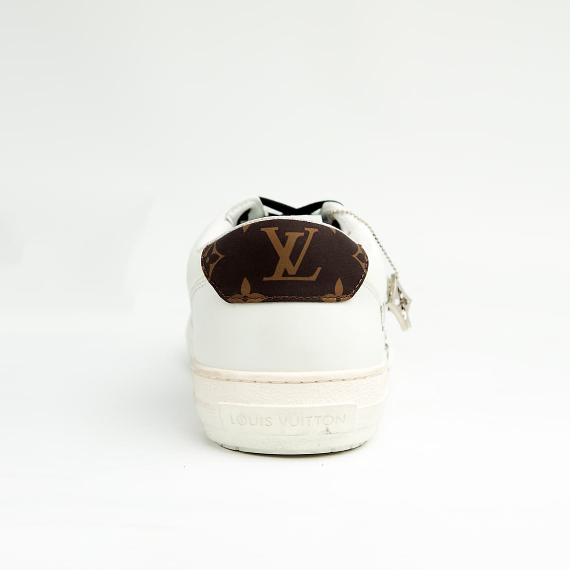 Louis Vuitton Black Heart unisex sneakers in white and black leather with LV heart motif and logo charm — luxury designer footwear.
