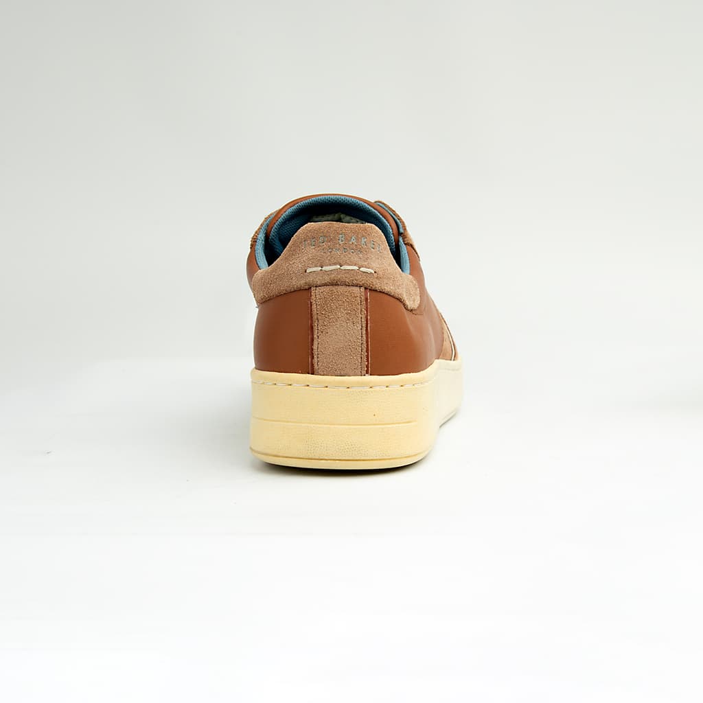 These versatile sneakers are crafted from a sophisticated mix of materials, featuring smooth brown leather panels complemented by textural suede accents in a matching tonal palette.
