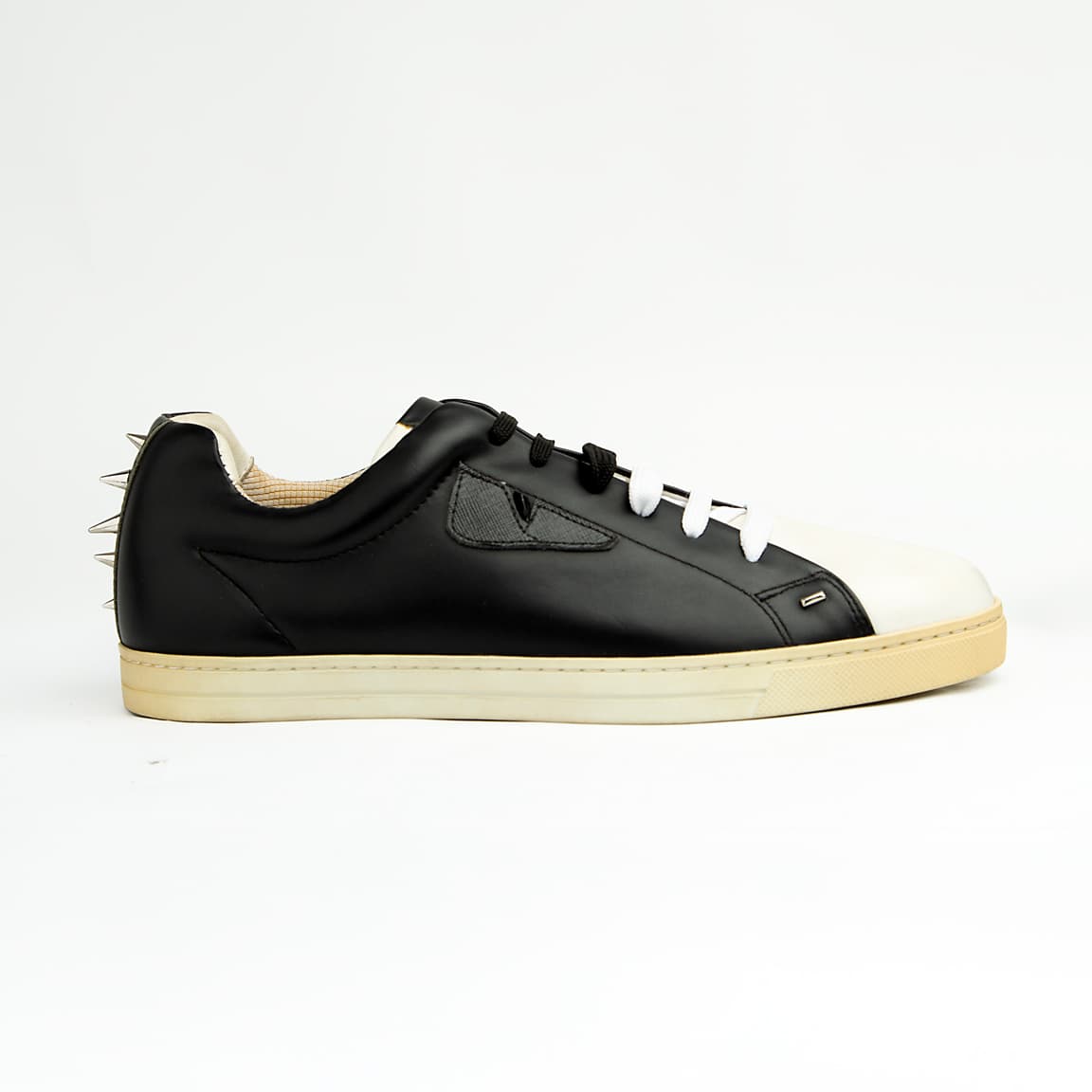 These sleek, premium leather sneakers perfectly blend classic low-top styling with the brand's signature playful-yet-edgy aesthetic.