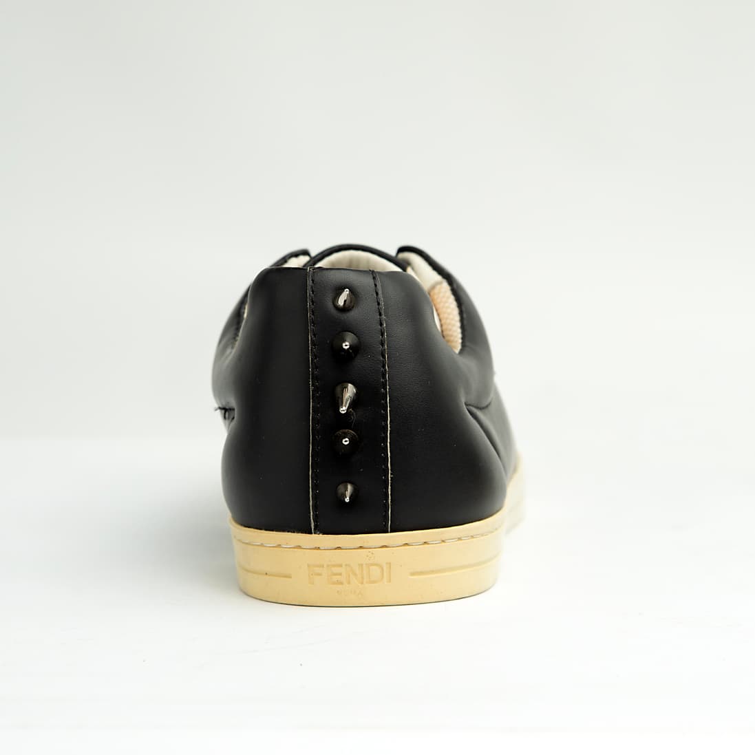 These sleek, premium leather sneakers perfectly blend classic low-top styling with the brand's signature playful-yet-edgy aesthetic.