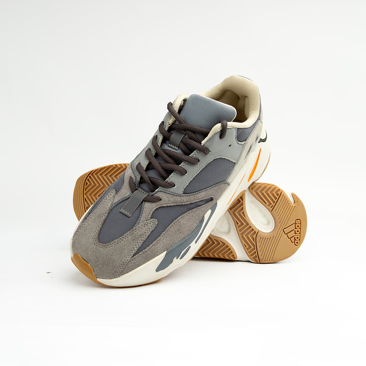 Grey and orange unisex chunky retro sneakers with suede, mesh, and leather detailing.