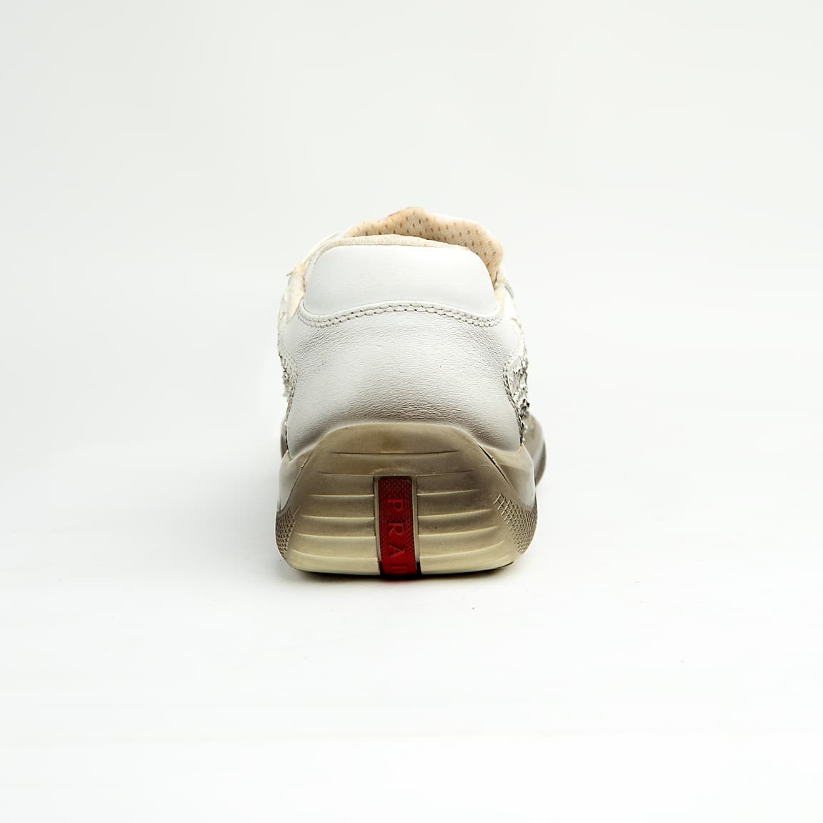These high-fashion sneakers feature a unique white leather upper with a striking, textured cracked/distressed finish that fades dramatically into a darker, almost gradient effect at the midsole line, evoking the look of a receding glacier or ancient ice.