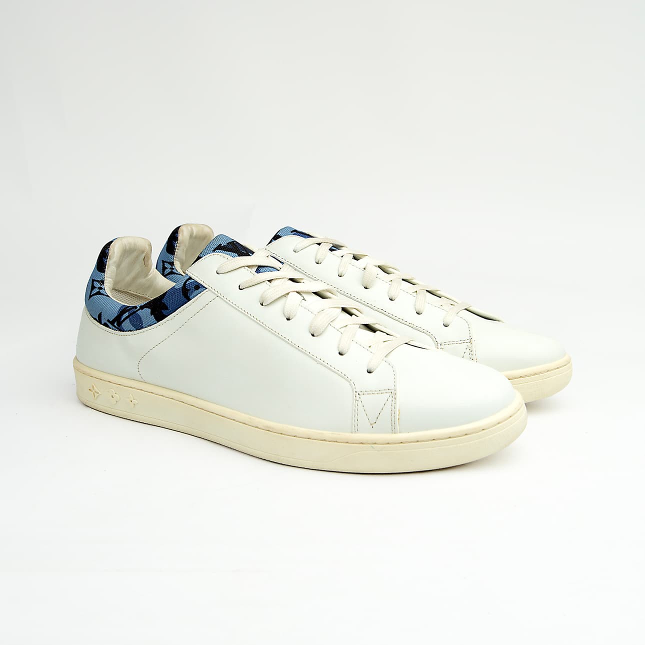 White Louis Vuitton unisex sneakers with blue monogram denim detail and white sole.