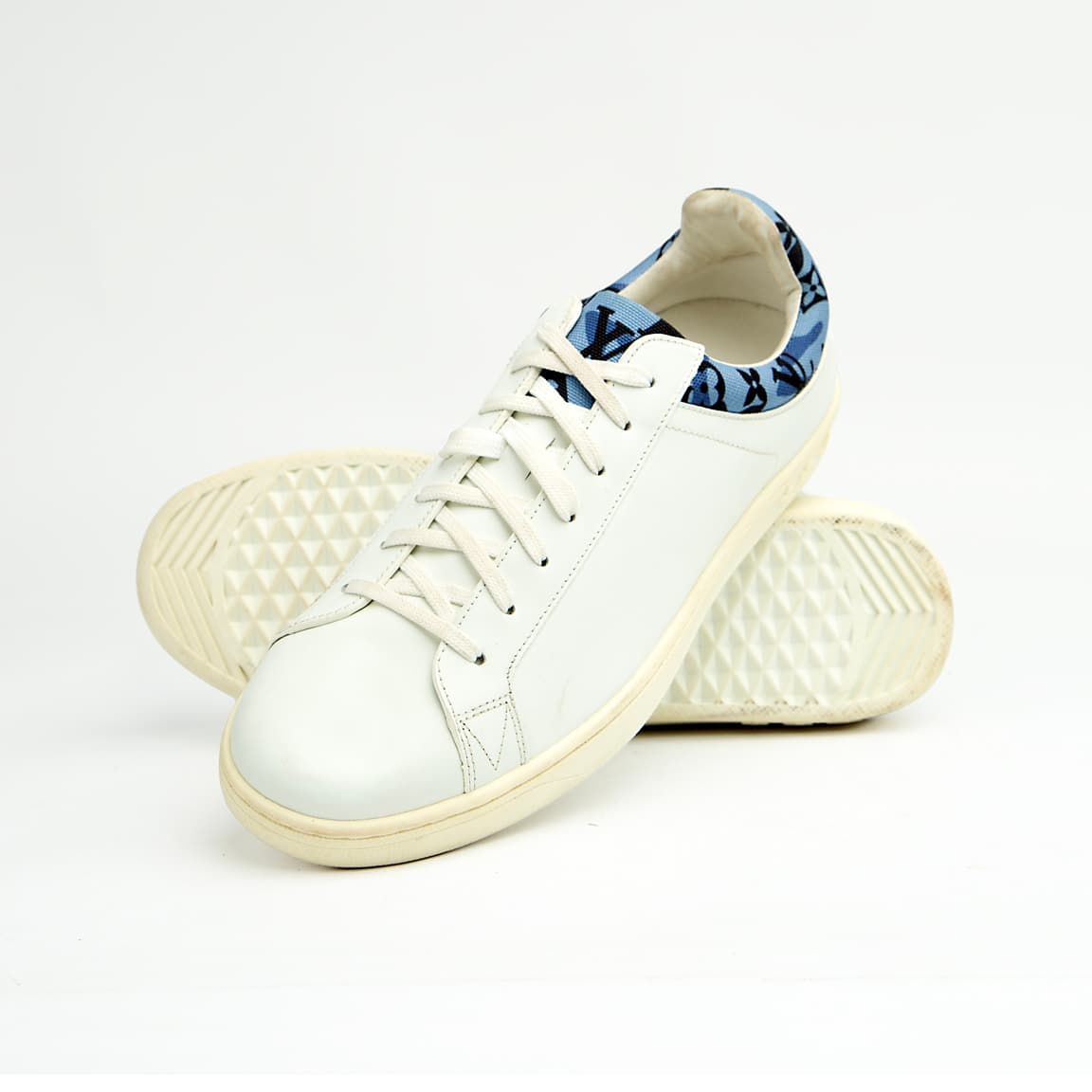 White Louis Vuitton unisex sneakers with blue monogram denim detail and white sole.