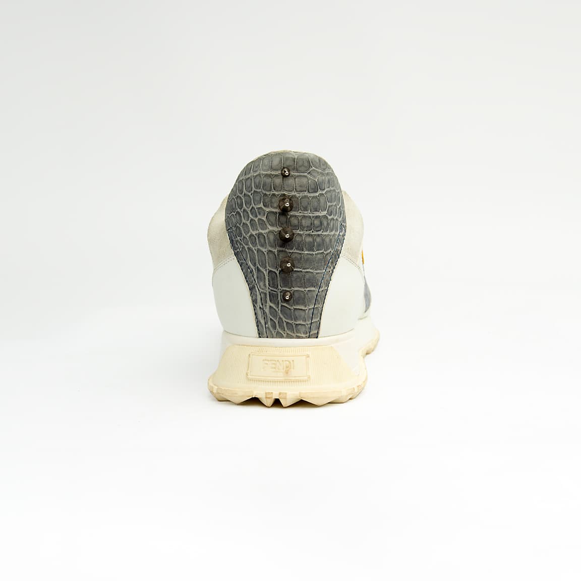 Crafted from premium leather, it features contrasting grey crocodile-embossed leather panels and a striking yellow-and-black triangular appliqué, reminiscent of a watchful eye.