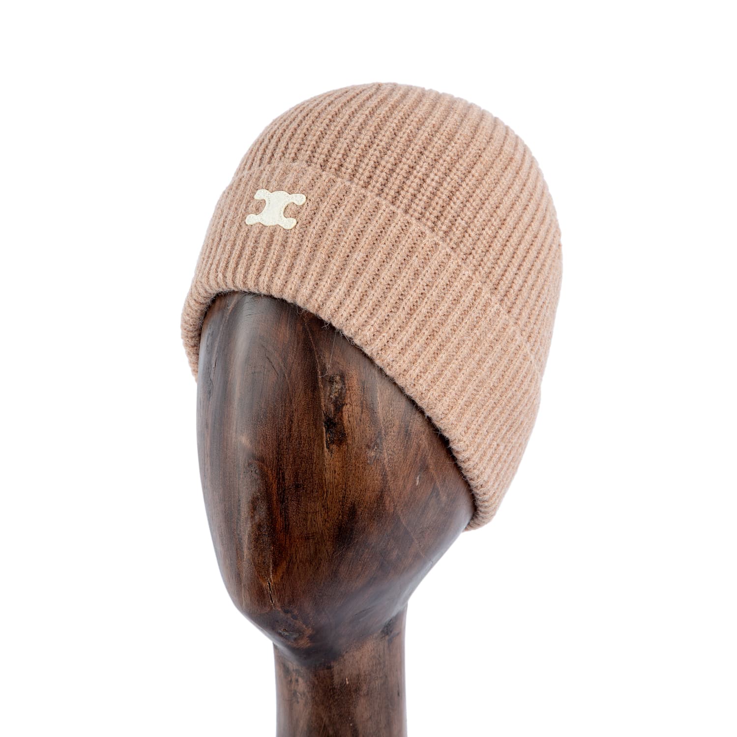 Ribbed camel brown knit beanie with metallic logo, stylish winter hat on wooden stand.