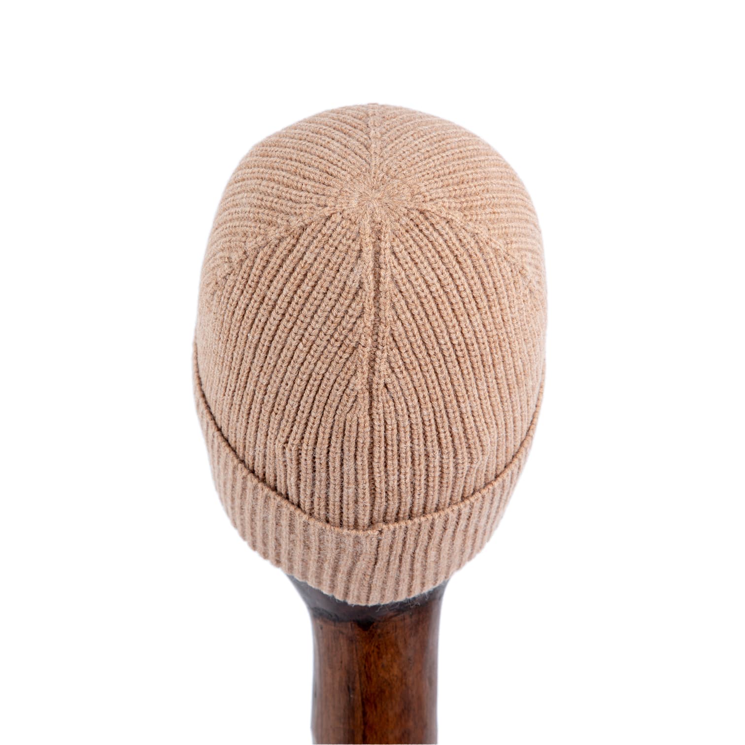 Ribbed camel brown knit beanie with metallic logo, stylish winter hat on wooden stand.