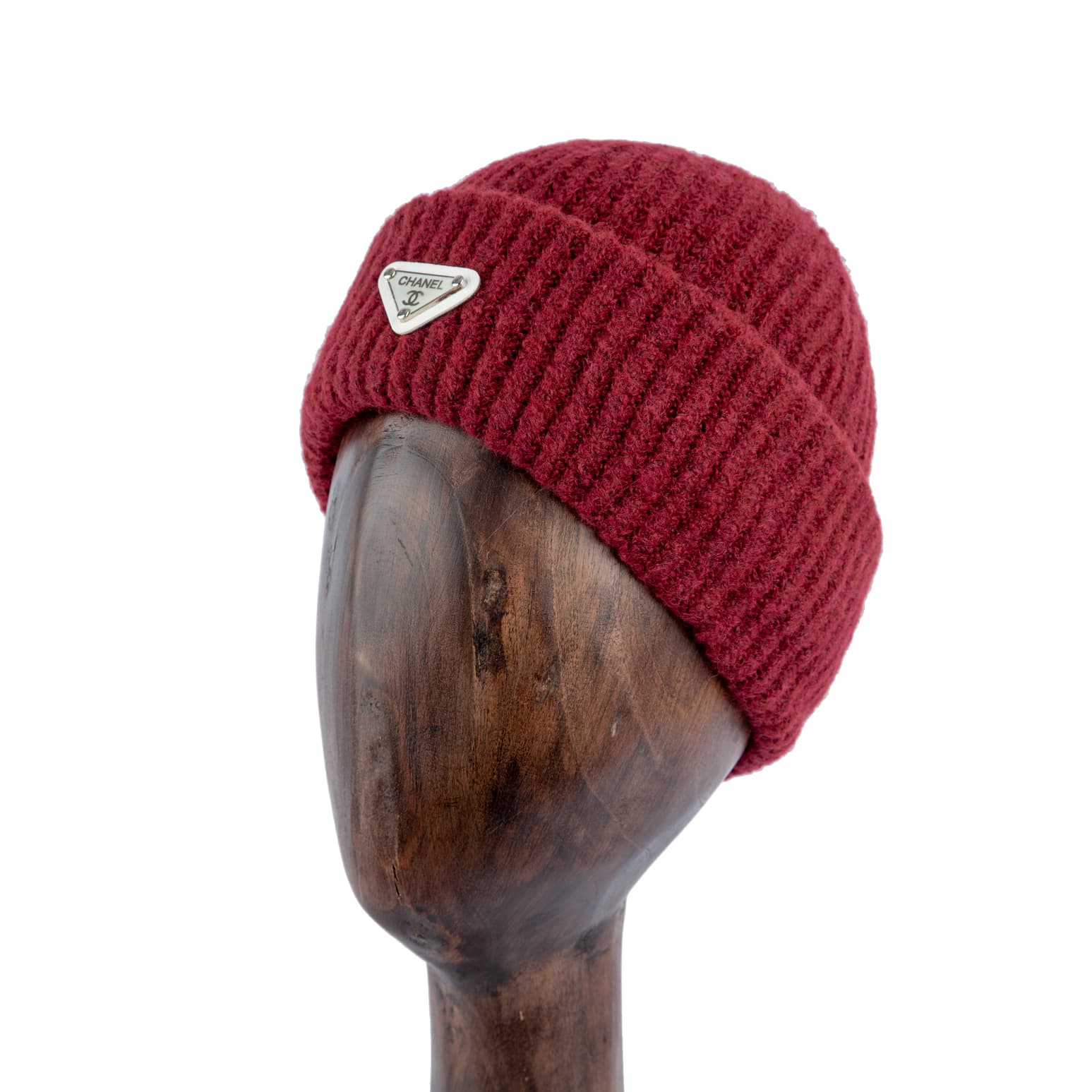 Burgundy ribbed wool beanie with silver metal emblem, perfect for winter warmth and a stylish statement.
