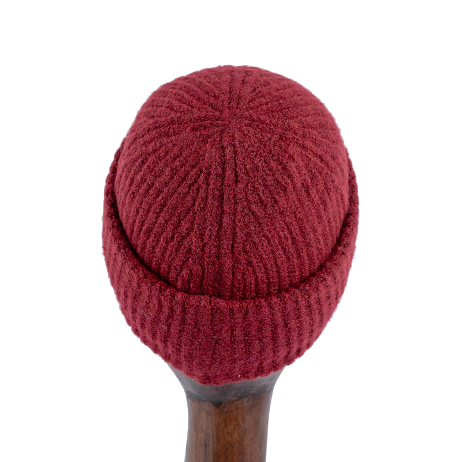 Burgundy ribbed wool beanie with silver metal emblem, perfect for winter warmth and a stylish statement.