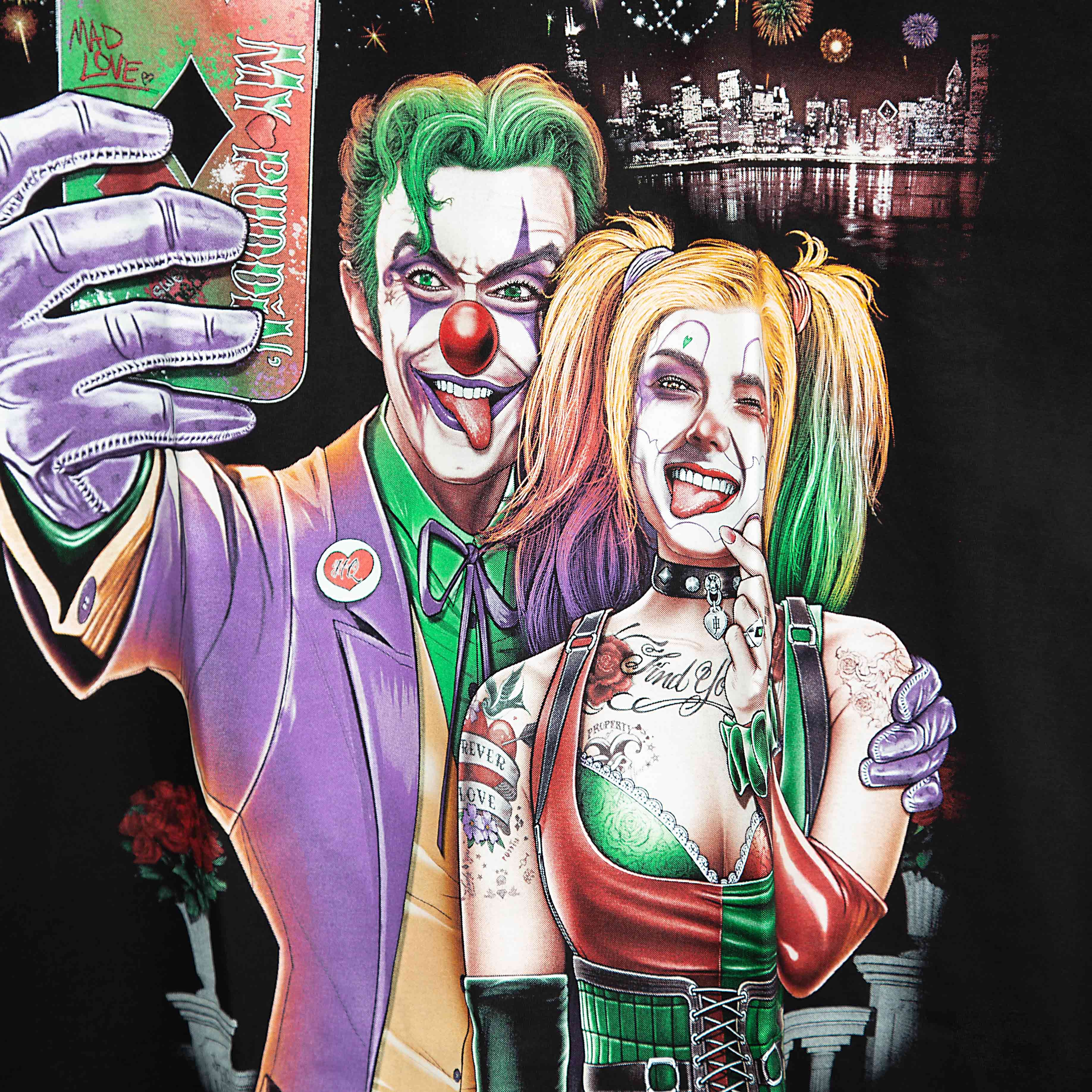 Rock Eagle black unisex t-shirt with a detailed graphic of the Joker and Harley Quinn taking a selfie against a night city skyline with fireworks.