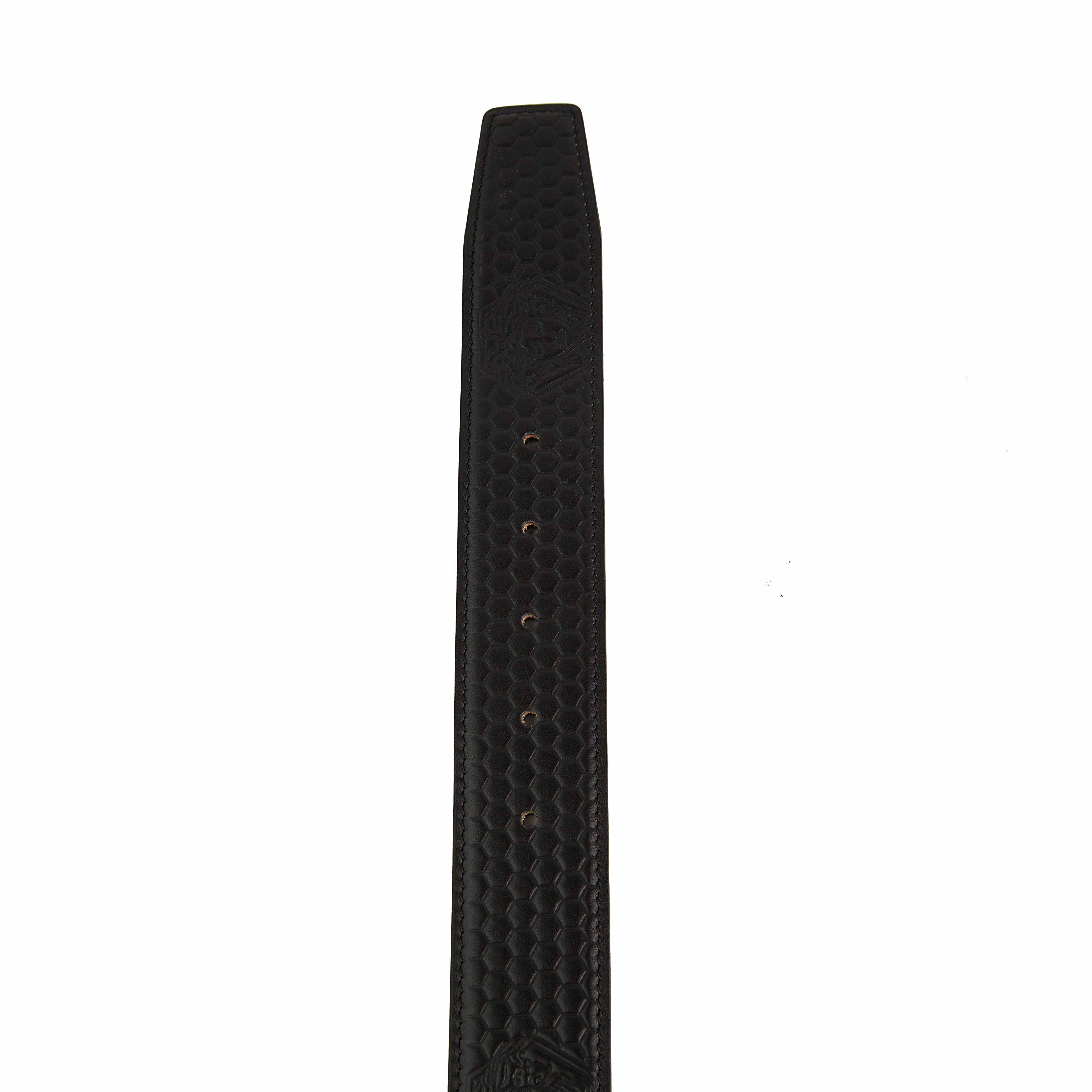 This statement accessory elevates the classic black leather belt through intricate detailing.